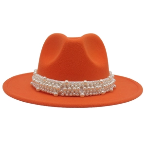 Detail of orange wool fedora with decorative white pearls on the wide brim band