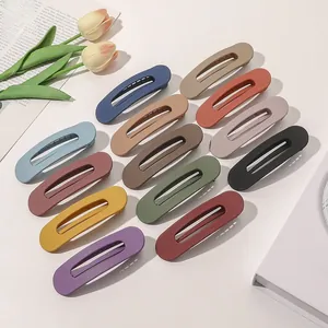 Detailed view of matte textured hair clips in thirteen various Morandi colors set on a white desk