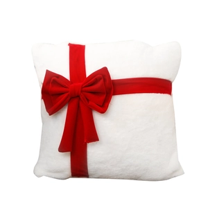 White plush Christmas pillow with a large red ribbon bow design in a gift box style