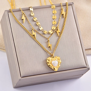 Gold layered necklace set featuring a hammered heart pearl pendant and lightning charms