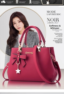 Close-up of wine red PU leather handbag featuring decorative bow and star pendant detail