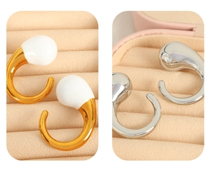 Macro shot of minimalist gold and silver C-shaped hoop earrings on a pink velvet display
