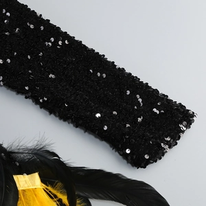 Detail of elegant V-neck dress with black sequins and vibrant yellow feather accents