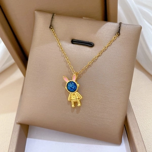Nahaufnahme der goldenen Hasen-Halskette mit blauem Edelstein in einer Geschenkbox