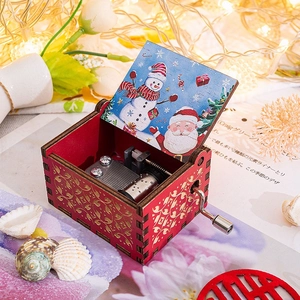 Detail of hand-cranked wooden music box with metal mechanism and Christmas illustrations