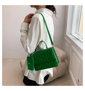 Green quilted crossbody bag with adjustable strap and mini pouch shown on a model