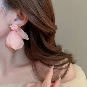 Close-up of model wearing pink lace flower earrings with beads and silver needle studs