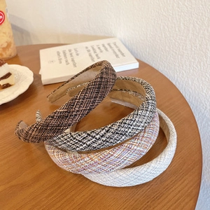 Detail of four colorful tweed headbands showing thick woven texture and vintage pattern