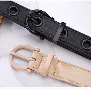 Detail view of punk style belts with eyelet holes in black leather and beige textures