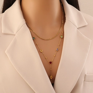 Detail of a gold-tone Y-shaped necklace featuring vibrant multi-colored glass gemstones