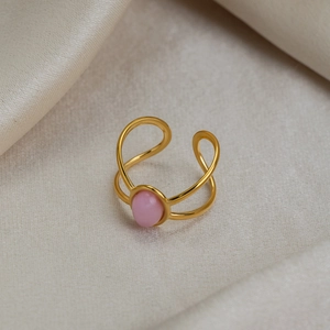 Detail of pink oval natural stone set in an 18K gold-plated adjustable stainless steel ring