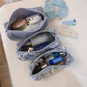 Three assorted ocean blue floral and corduroy zipper pouches showing storage capacity