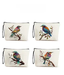 Detail display of four canvas toiletry bags with realistic bird and leaf illustrations