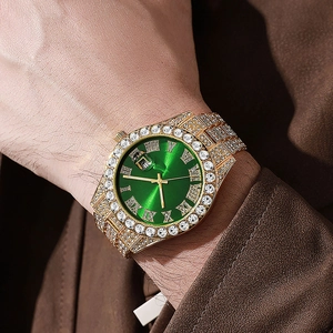 Close-up of luxury gold-plated watch with green dial and sparkling crystal rhinestones