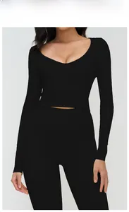 Détail du haut de yoga noir à manches longues avec col en V et legging assorti