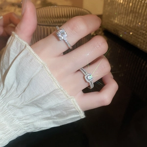 Macro shot of two silver rings with sparkling zircon stones on a model's hand
