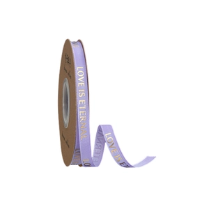 Detail of light purple LOVE IS ETERNAL gold foil ribbon on a kraft paper spool