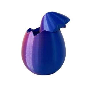 Piccolo drago stampato in 3D che esce dall'uovo con finitura in seta viola e blu