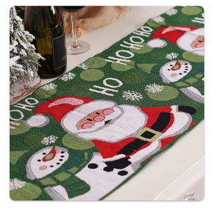 Détail du chemin de table de Noël tricoté vert avec motifs Père Noël et bonhomme