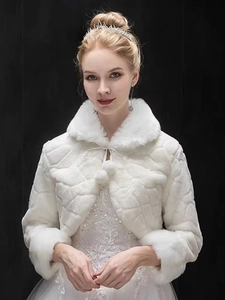 Detail of white bridal faux fur shrug with diamond texture and pompom drawstring