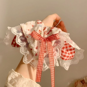 Detail of red plaid bow hair scrunchie with white lace trim and Strawberry Baby print
