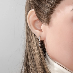 Star charm hoop earring with small crystals in silver finish shown on model