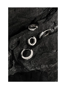 Detailed macro view of S925 sterling silver huggie earrings with sparkling zircon inlay