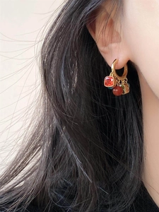 Detail of ethnic gold hoop earrings with zircon, agate beads, and vintage tassels