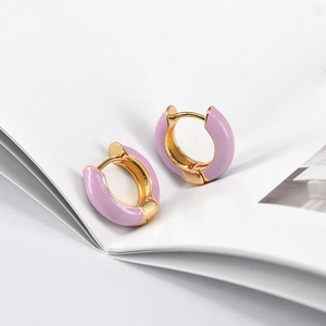 Close-up of lavender purple enamel hoop earrings with gold metal base on white background