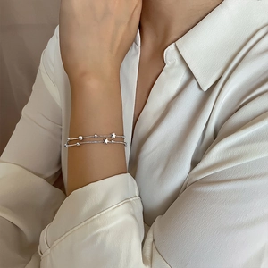 Double-layered silver star bracelet for women featuring delicate beads and star charms
