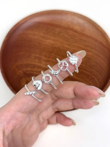 Close-up of five S925 sterling silver rings featuring heart and clover shapes on fingers