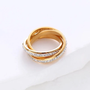 Close-up of gold interlocking three-band ring set with sparkling white crystals