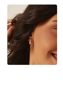 Close-up of S925 silver 14K gold-plated irregular twist hoop earrings with micro-set zircons