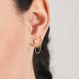 Close-up of S925 silver gold chain earring with white opal and double piercing design