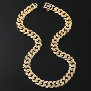 Hiphop iced out gold Cuban link chain necklace with sparkling crystals on black surface
