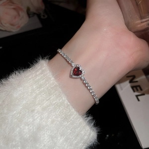 Detailed view of silver heart bracelet with red ruby and sparkling white diamonds