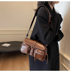 Detailed side view of a brown vintage PU leather crossbody bag with silver buckles