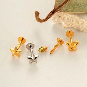 Titanium star and butterfly labret studs in gold and silver finish with green gemstone