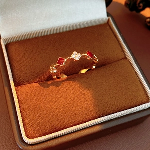 Detail of 18k gold ring with red clover motif and shimmering cubic zirconia stones
