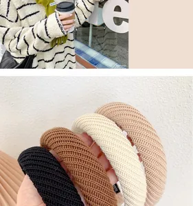 Detailed view of wide knitted headbands in black, beige, and caramel autumn tones