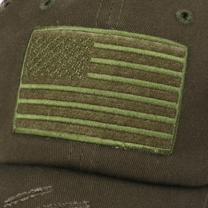 Close-up of distressed olive green baseball cap with embroidered American flag patch detail