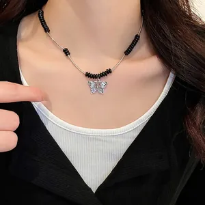 Vintage butterfly pendant necklace with black beads and silver chain on model