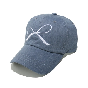 Detailed close-up showing white embroidered bow and texture on blue denim baseball cap