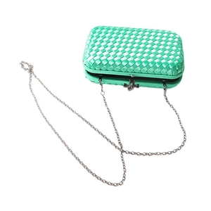 Elegant emerald green woven clutch bag with a silver chain strap for evening events