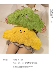 Detail of plush croissant pillows in green and yellow with cute embroidered faces