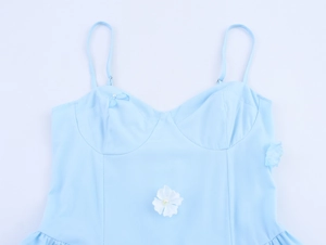 Detail of light blue floral strap dress with white flower accent and small bows