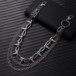 Close-up of triple-layered silver metal pants chain with punk spikes on black leather wallet