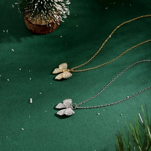 Detail view of gold and silver butterfly pendant necklaces with sparkling zircons