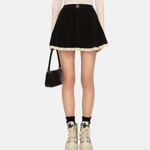 Jupe plissée vintage en maille noire avec bordure blanche contrastée et détail en métal