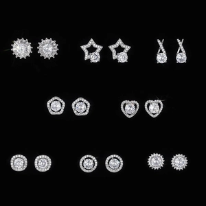 Set of silver flower and heart stud earrings with sparkling cubic zirconia on black background